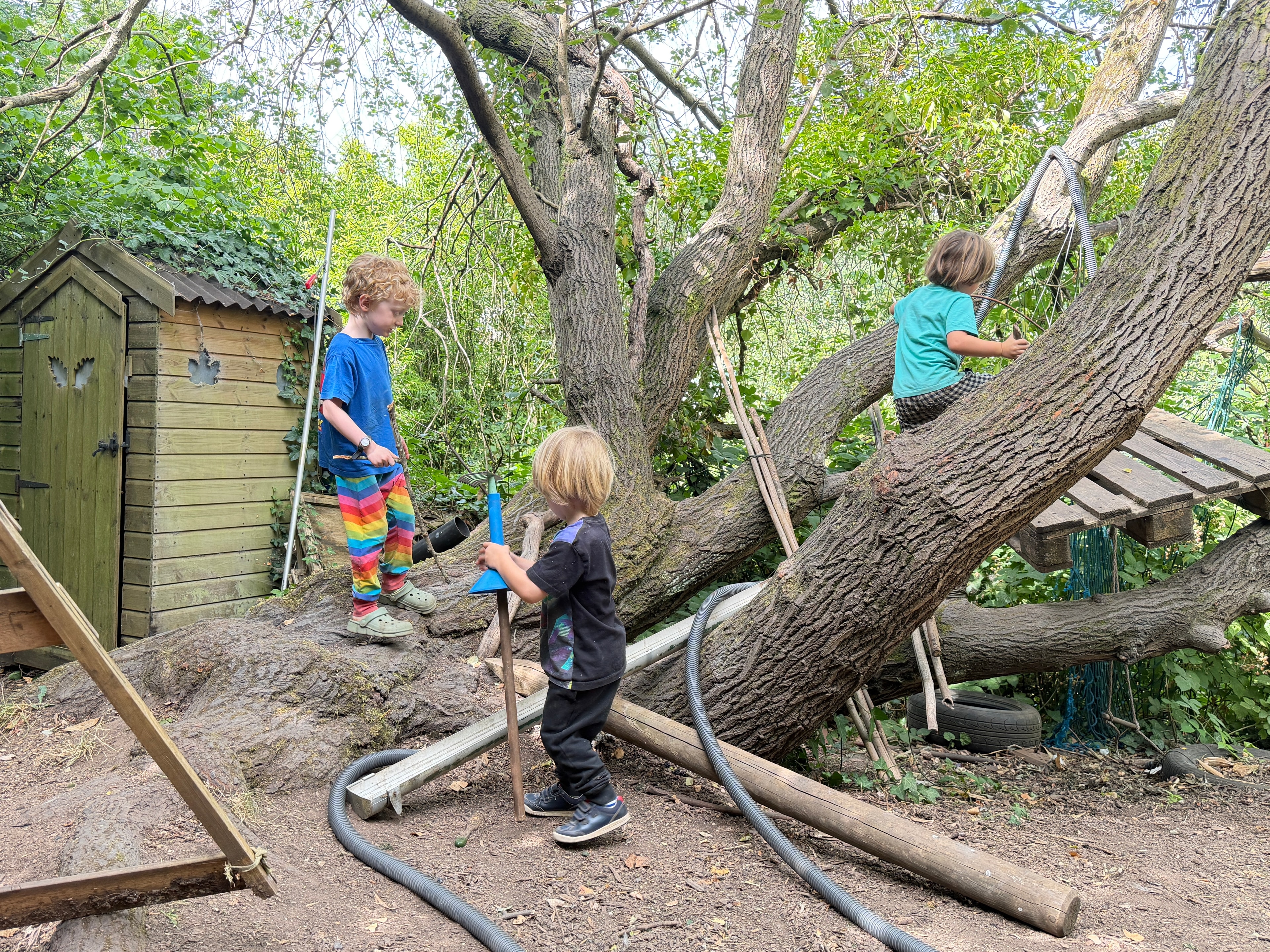 Children playing in the garden with mud kitchen and natural materials